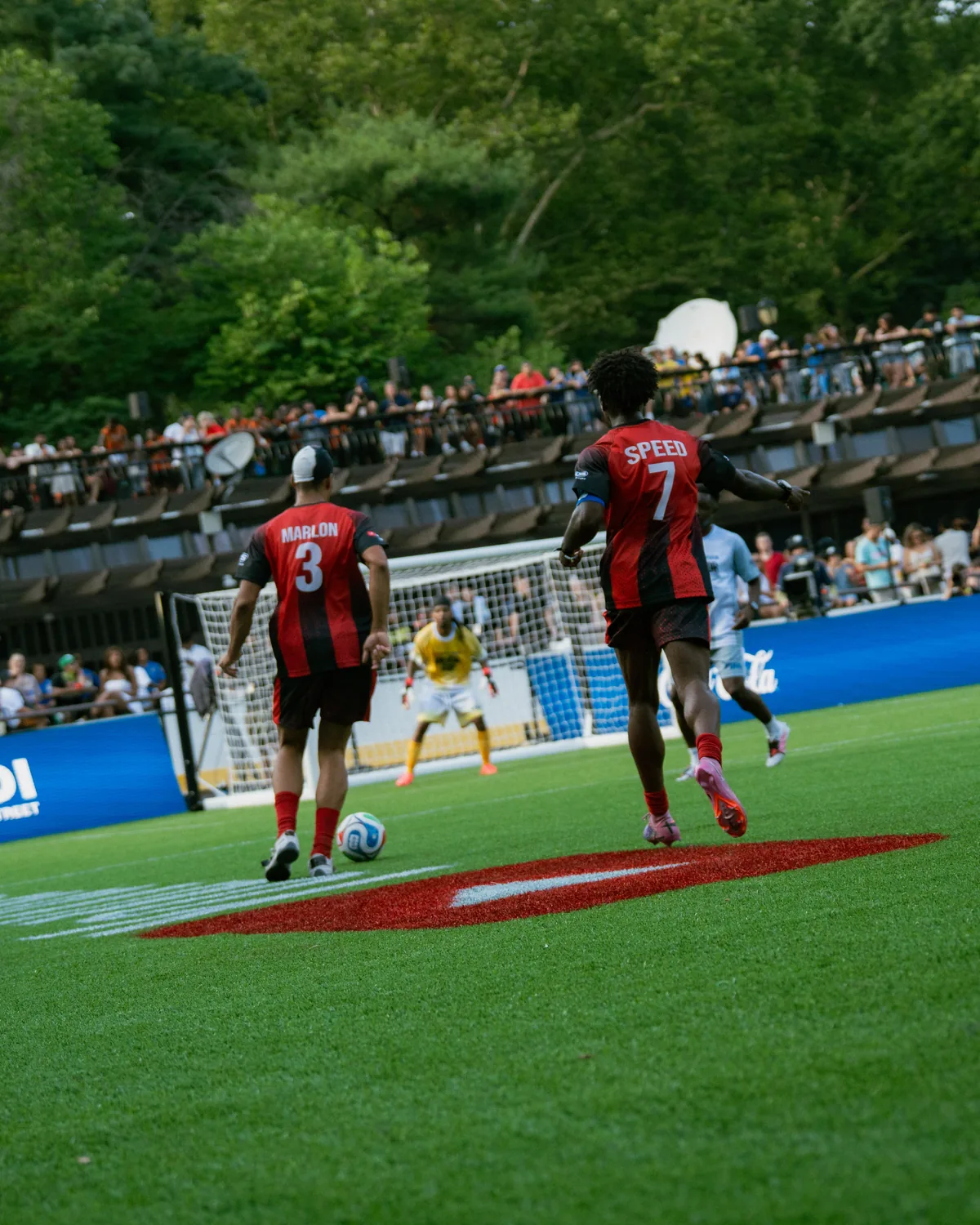 Players in red and black kits on the pitch during the match