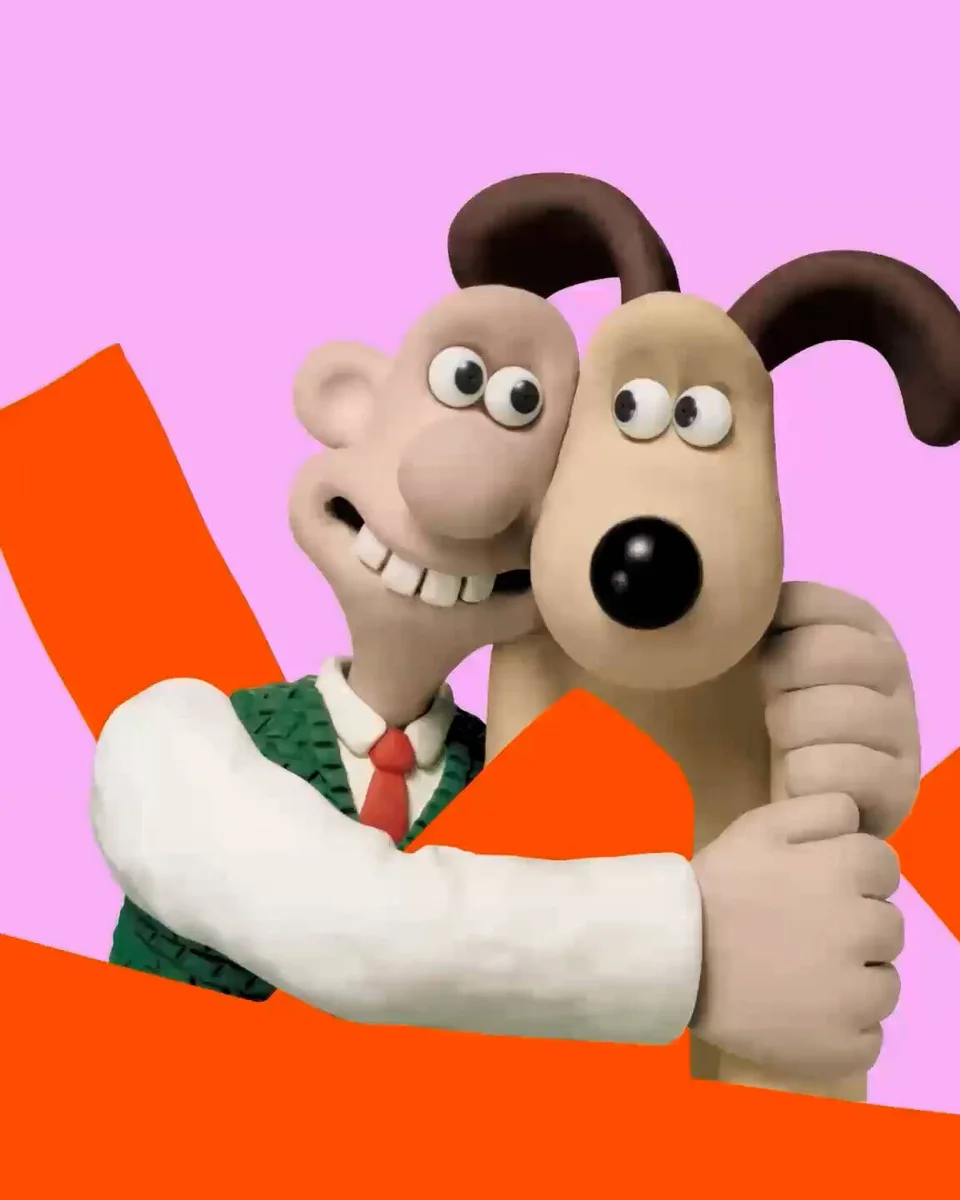 Young V&A Inside Aardman artwork: Wallace and Gromit hugging on a pink background